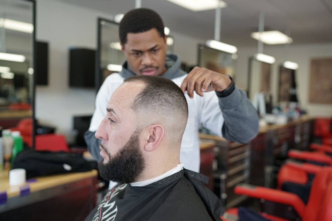 man doing a fade on another man's hair
